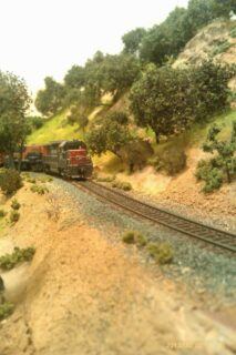 THE COMPLETED SCENE, NOW COMPLETE WITH RAILWAY BALLAST AND A TRAIN DROPPING DOWN THE GRADE.