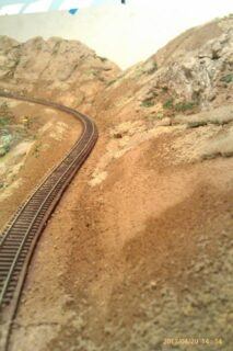 A STRETCH OF TRACK ALONG AN S CURVE ON MY N SCALE MODEL RAILROAD. THE BASE SCENERY IS IN AND THE ROCK OUTCROPPINS HAVE THEIR BASE COLOR